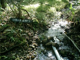 清水が流れる、山頂水源地の標識